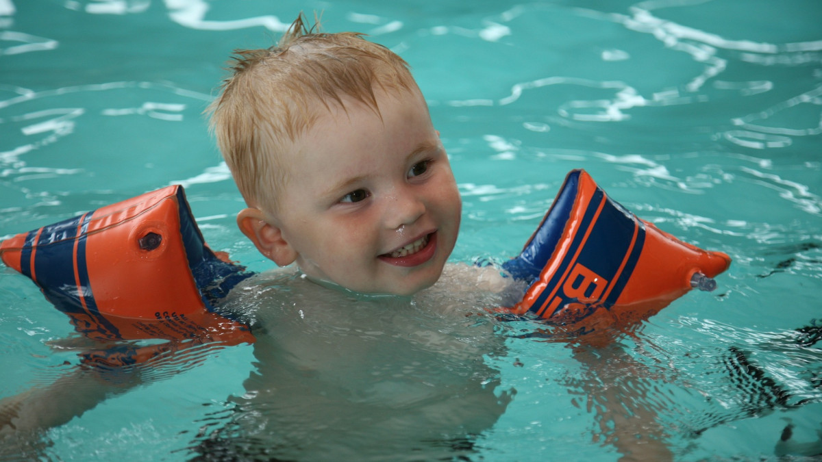 Ребенок с поплавками в бассейне.
