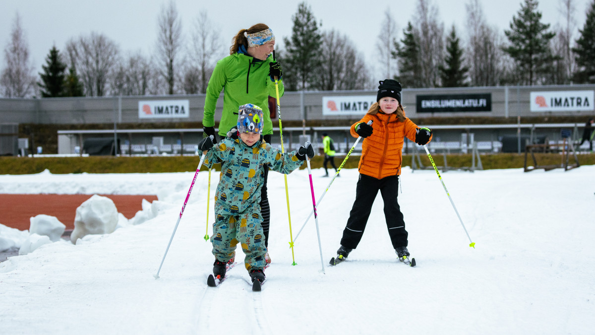 Perhe hiihtää ensilumenladulla