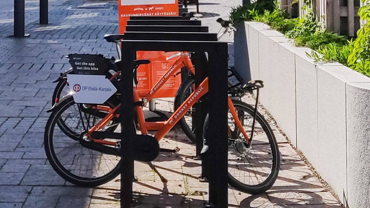 Orange city bikes on a summer day at their own station.