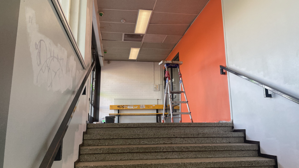 Aseman sisäpintojen maalaustyöt ovat käynnissä. KUvassa oranssin seinän maalaus.