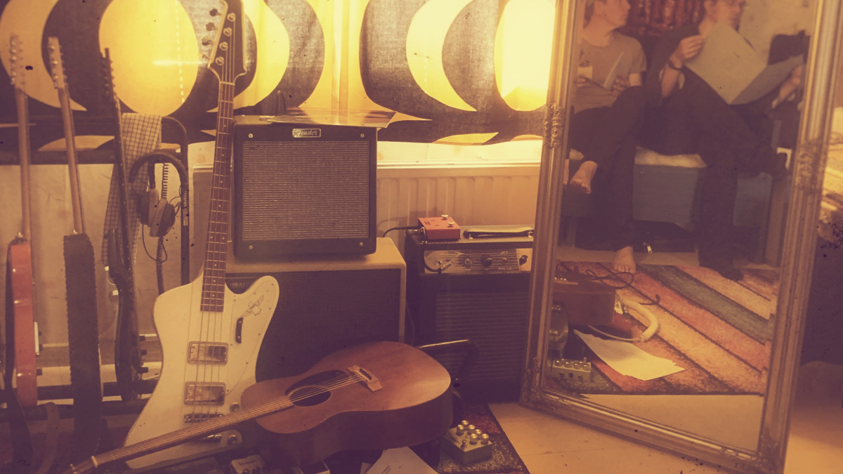 Hämärä huone, jossa on soittimia ja muita musiikin tekemiseen liittyviä välineitä.