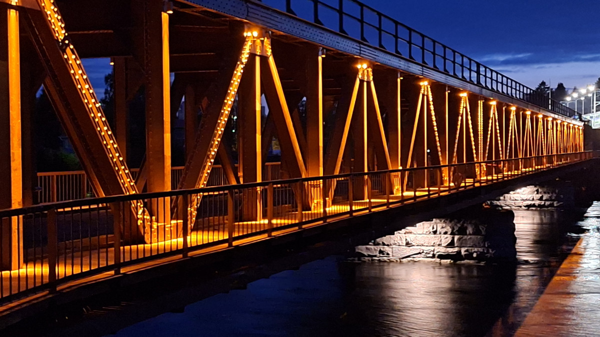 Старый железнодорожный мост Мансиккакоски в вечернем освещении в синий момент в Иматре.