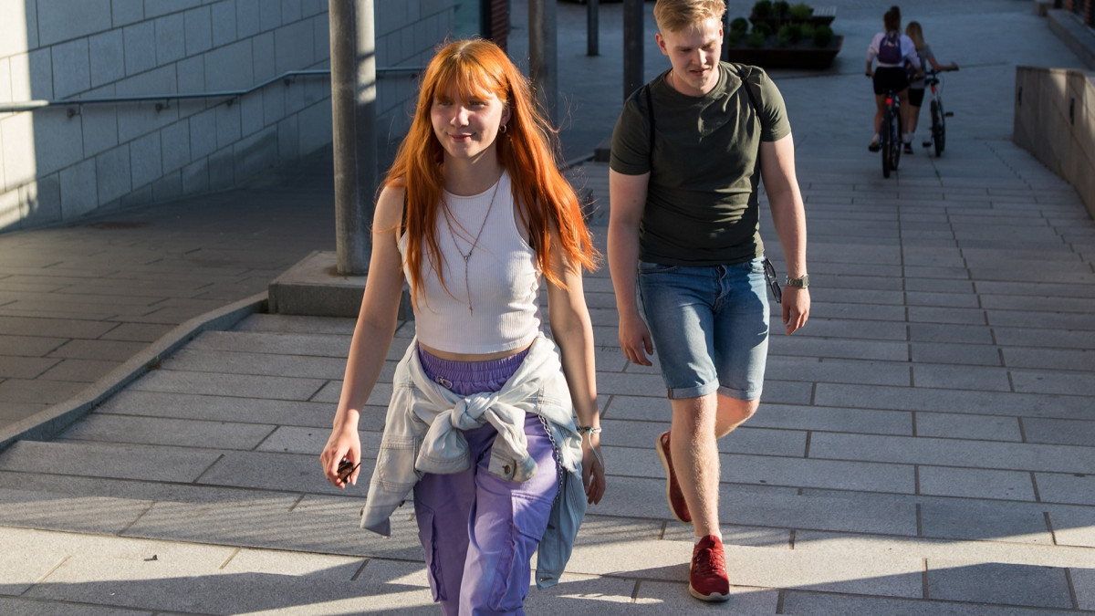 Two young people walking down the street.