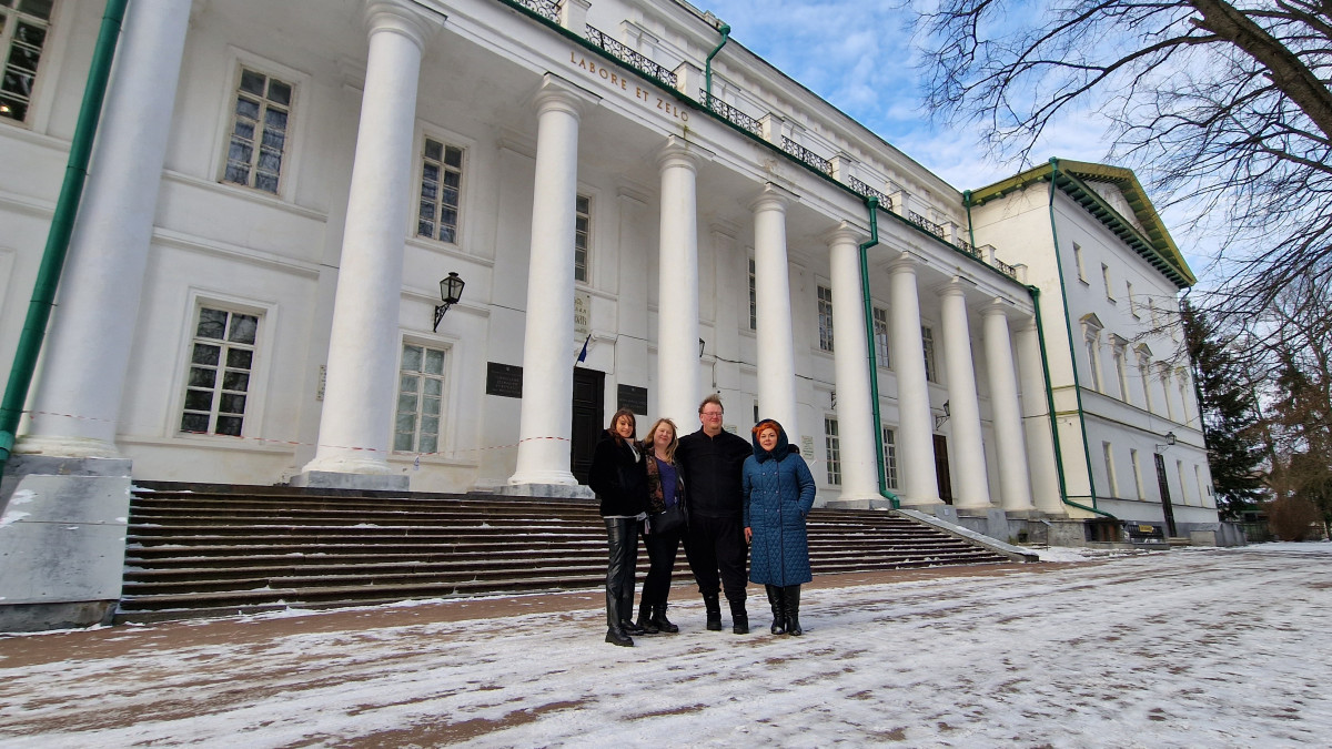 Four people standing in front of a classical building.