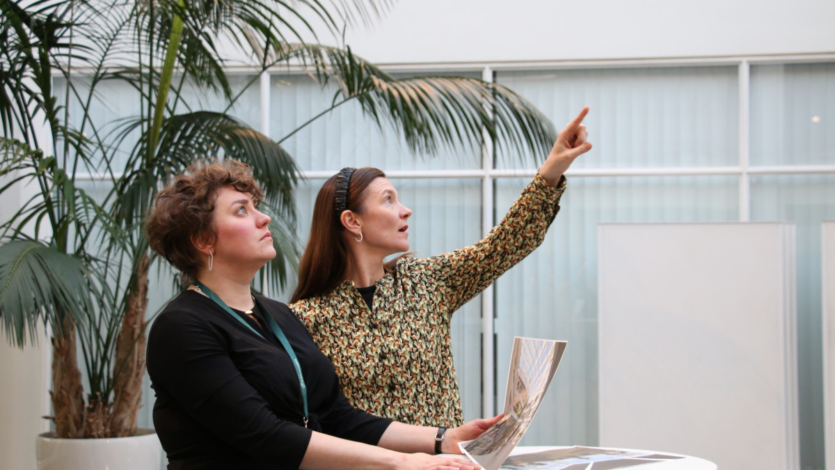Ilona Tuomi ja Laura Kokki seisovat Imatran kaupungintalon aulassa ja esittelevät Erä- ja luontokulttuurimuseon suunnitelmia.
