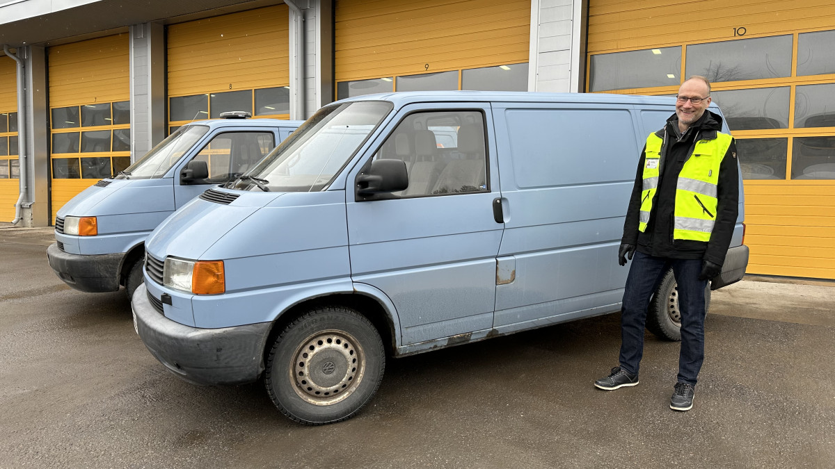 Imatran Kipa's CEO Markku Puuska and two blue vans bound for Nizhyn in front of the hall with the yellow door.