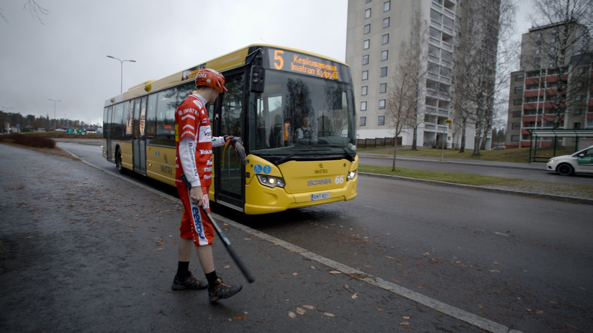 Pesäpalloilija varusteissaan nousemassa bussiin.