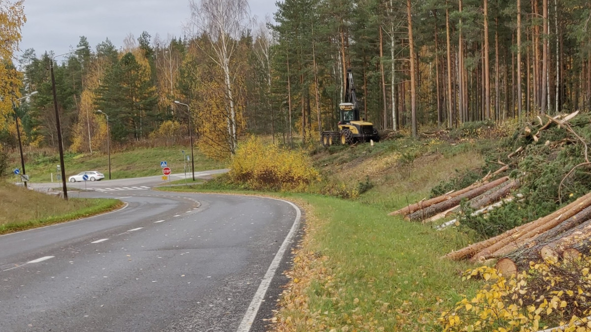 Trees felled from the edge of Asemäenti, forest machine at work.