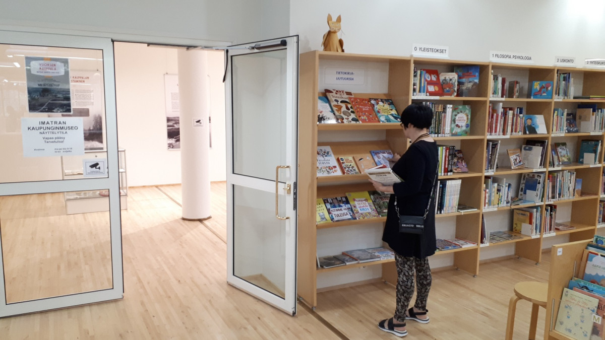 Kirjaston kirjahyllyjen vieressä on avoin ovi kaupunginmuseon näyttelytilaan.