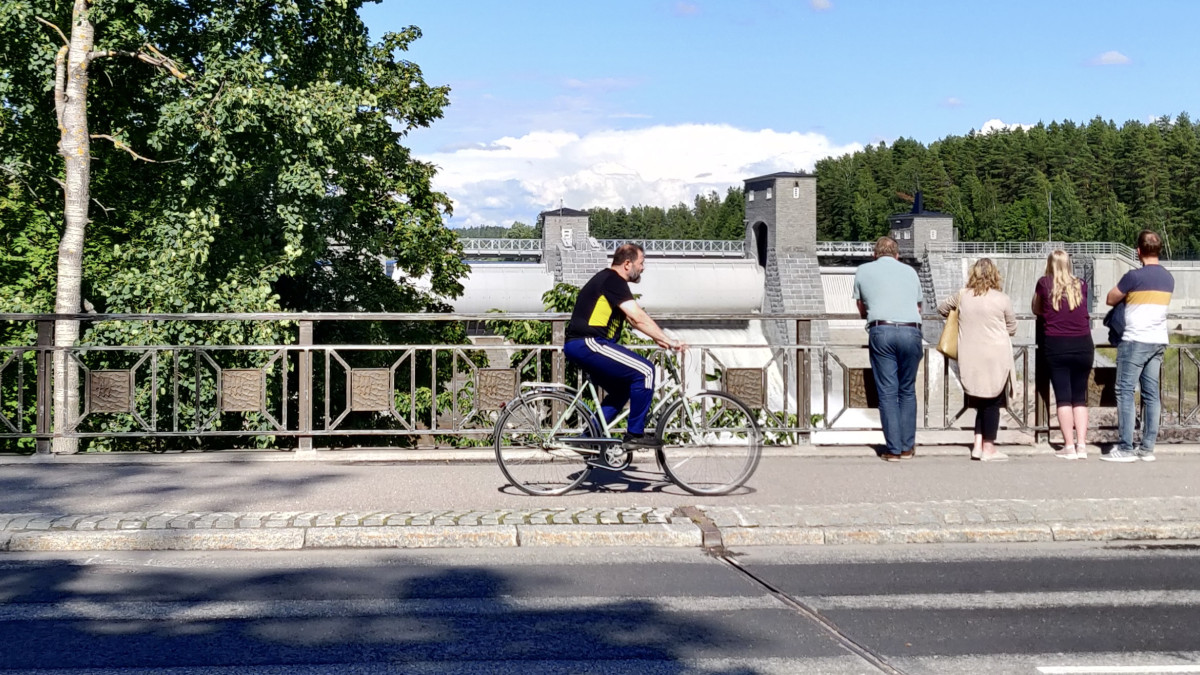 Imatrankoski, sillalla ihmisiä katsomassa koskea ja yksi pyöräilijä.