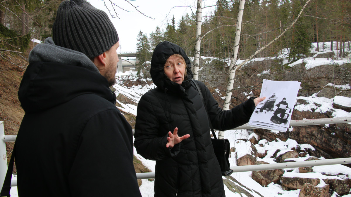 Minna Kähtävä-Marttinen explains to product developer Paavo Happose how historical figures have sat on the edge of the rapids.