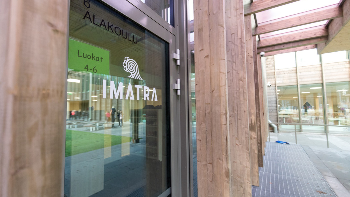 The school's glass outer wall, wood and the Imatra logo