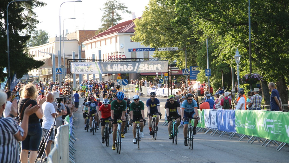 Pyöräilijät lähtöpaikalla ja yleisöä kannustamassa Imatrankoskentiellä 2021.
