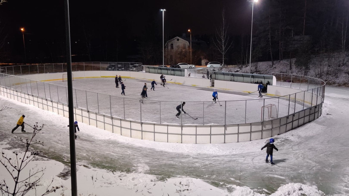 Field from above, players in the rink and skaters on the edges.