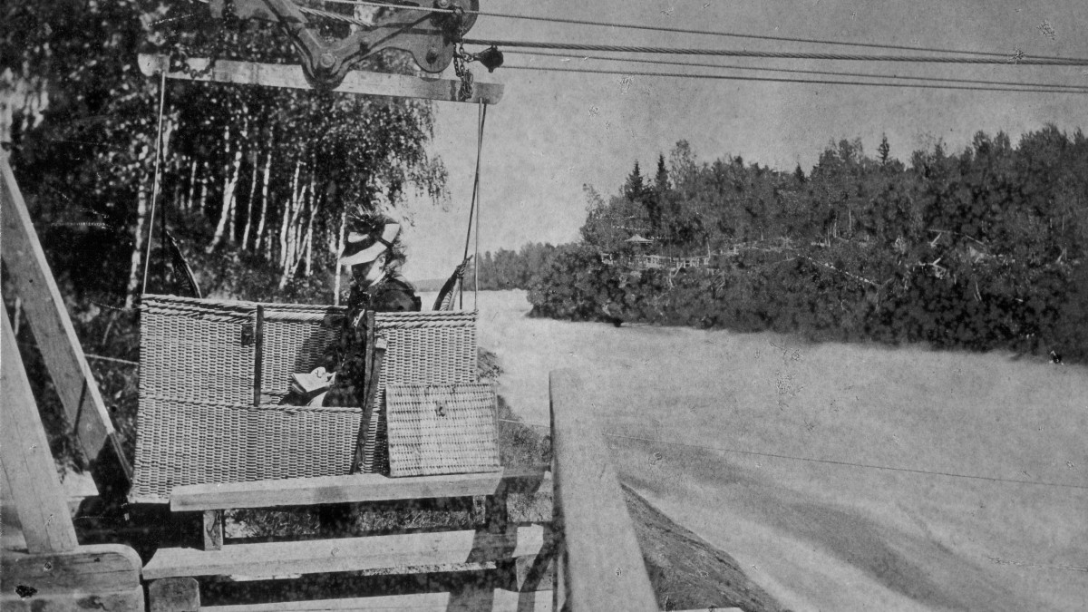An old picture of a rapid with a basket going over it.