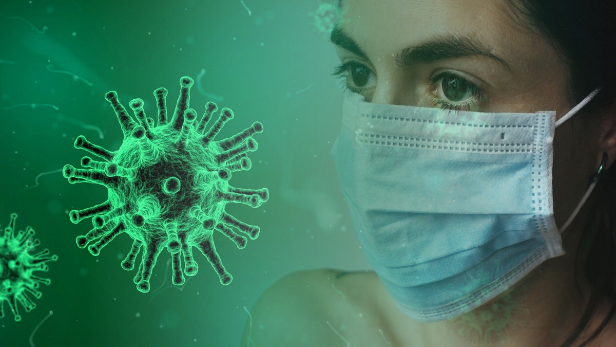 Женщина в маске, рядом с ней изображен коронавирус