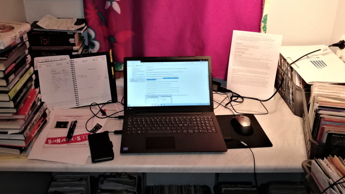 Remote workstation in closet, laptop, books and papers.