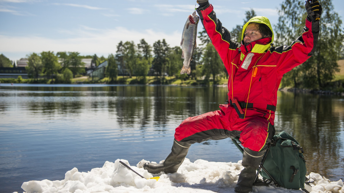 A man with a fish he caught on an ice raft in summer Vuok