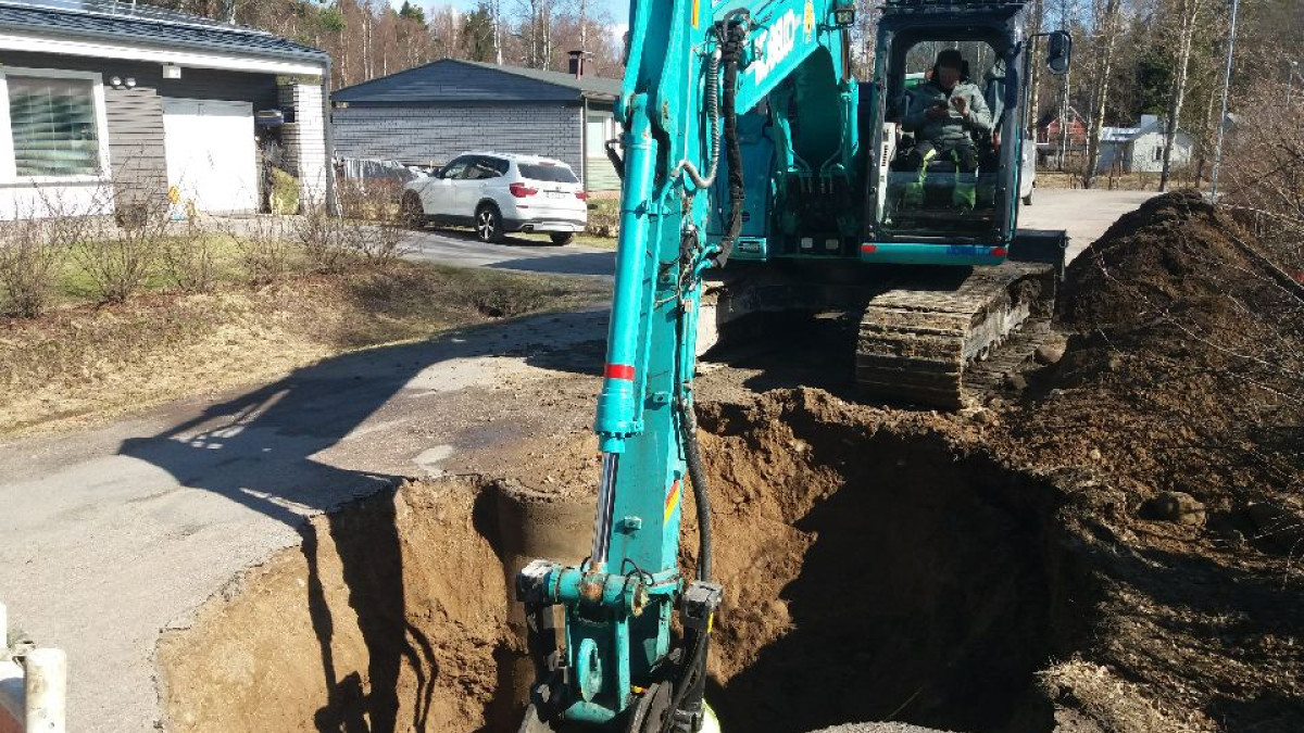 An excavator digs out a water pipe.