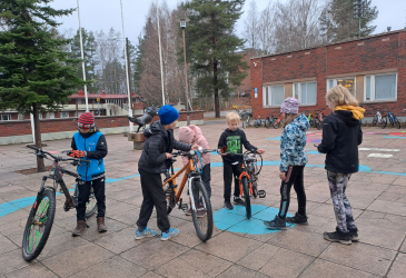 Children with bicycles in the school yard.