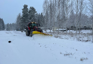 Traktori auraa lunta.