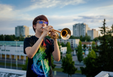 A man plays the horn on a summer evening in Imatra.