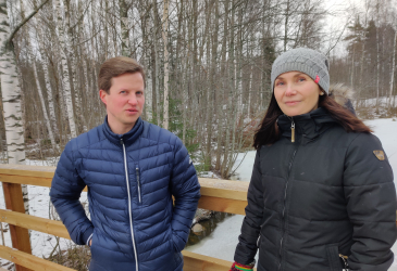 Ville ja Tiia seisovat puisella Virasojan ylittävällä kävelysillalla