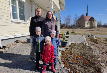 Vesterisen viisihenkinen perhe kuvattuna kotitlaonsa ja Tainionkosken kirkon edustalla.