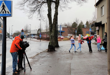 Kuvaaja ja kuvattavat oppilaat kadulla.