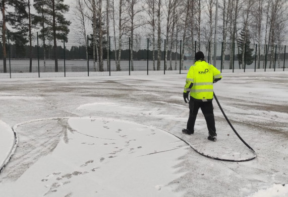 An employee of the property service freezes the outdoor field.