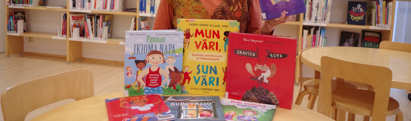 A woman with different picture books in front of her.