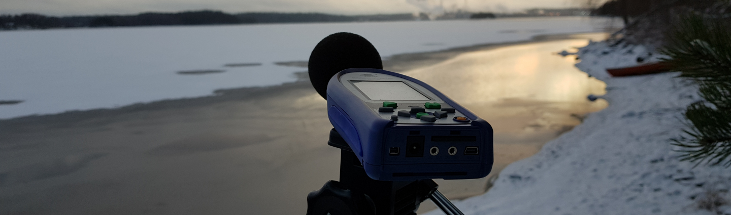 Noise measurement with a noise meter outdoors in a winter lake landscape.