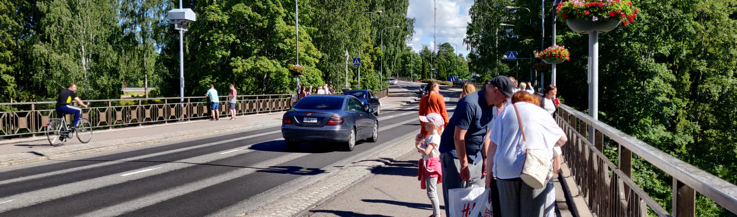 a bridge, a car, a cyclist and a pedestrian.
