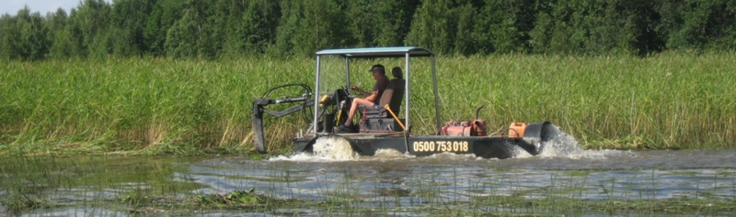 Water plant mower on the lake.