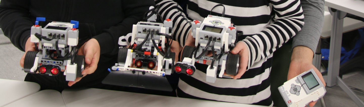 Boys smiling with lego robots in their hands