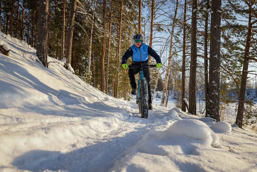 A mountain biker in a winter landscape. Sun shines.