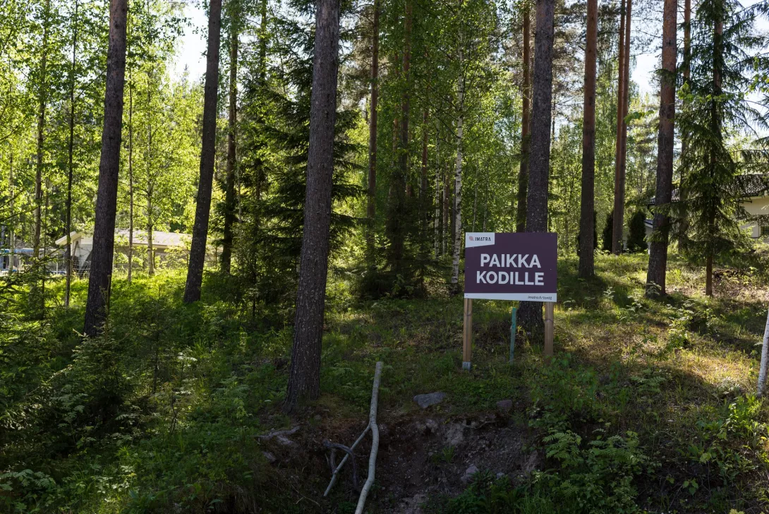 Ein Schild „Platz für Zuhause“ im Wald, auf dem Gelände.